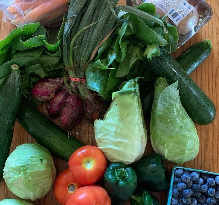 Assorted fresh vegetables and fruits on a wooden surface